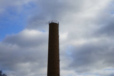 Ocak ayında gökyüzüne karşı kazan dairesinden baca dumanı tütüyor. Berlin, Almanya