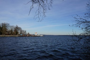 Ön planda Mueggelspree nehri ve arka planda Şubat ayında Grosser Mueggelsee gölü görülüyor. 12559 Berlin, Almanya