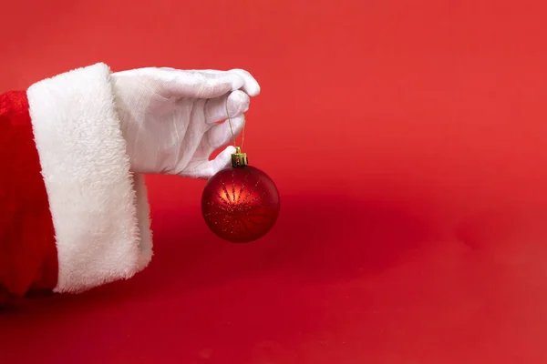 Mikołaj Ręka Piłką Świąteczną Czerwonym Tle Prezent Boże Narodzenie Nowy — Zdjęcie stockowe