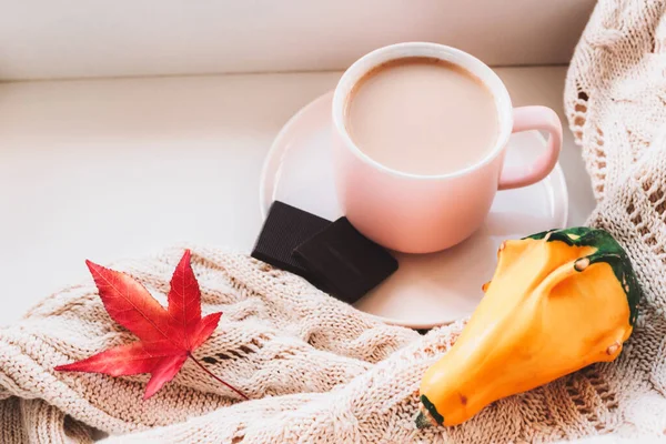 Filiżanka kawy latte i kawałki czekolady, żółta dynia i sweter na drutach na parapecie. Ciepła i przytulna jesień w domu. Widok z góry — Zdjęcie stockowe