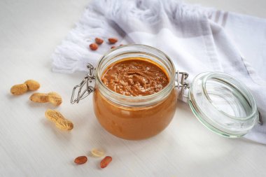 Cam kavanozda fıstık ezmesi ve bulaşık bezi. Üst görünüm.