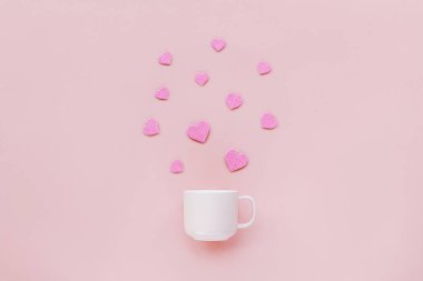İçinde kalpler uçuşan pembe arka planda bir kupa. Sevgililer Günü konsepti. Üst görünüm.