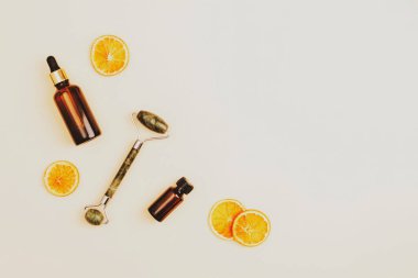 Kozmetik aksesuarlar, kurutulmuş portakal dilimleriyle doğal bej arka planda yaşlanmayı önleyen kozmetik güzellik malzemeleri. Üst görünüm, düz görünüm, kopyalama alanı.