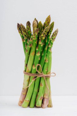 Beyaz bir masada taze yeşil kuşkonmaz, yakın plan..