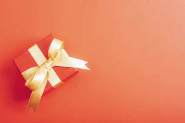 Kırmızı arka planda kırmızı hediye kutusu. Noel, yeni yıl, sevgililer günü konsepti. Üst görünüm, düz görünüm, kopyalama alanı.