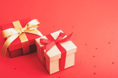 Two gifts boxes on red background, top view. New Year, Christmas concept.