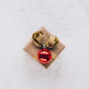 Kırmızı topun olduğu beyaz desenli bir kutuda Noel hediyesi. Yeni yıl konsepti. Üst manzara, düz uzanma.