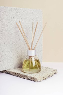 Aromatic incense, oil diffuser with reed sticks on white table. Isometric projection, copy space.