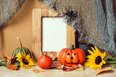 Boş resim çerçevesi, balkabakları, ayçiçekleri ve kuru yapraklar. Cadılar Bayramı konsepti.