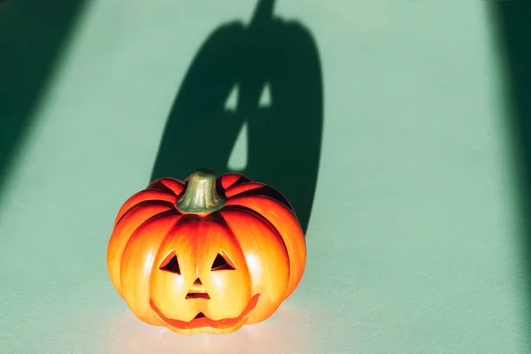 Jack-O-Lantern with strong shadow on blue background. Halloween concept.