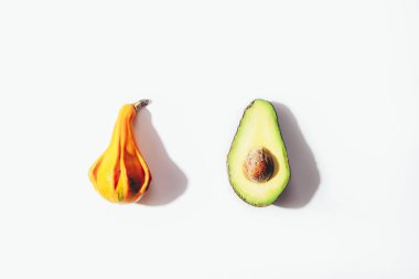 Beyaz arka planda sert gölgeli balkabağı ve avokado. Sağlıklı beslenme, vejetaryen yemeği. Üst manzara, düz uzanma.