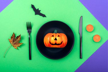 Cadılar Bayramı masası dekoratif balkabağı, yarasa, sonbahar yaprağı ve mumlarla dolu. Üst manzara, düz uzanma.