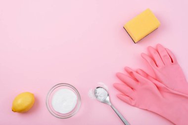 Temizlik eldivenleri, sarı sünger, kabartma tozu ve pembe arka planda limon. Çevre temizliği konsepti. Üst görünüm, düz görünüm, kopyalama alanı.