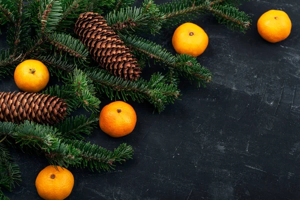 Weihnachtlicher Hintergrund Mit Mandarinen Tannenzweigen Zapfen Auf Schwarzem Tisch Ansicht — Stockfoto