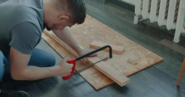 Adam evinde tadilat yaparak mobilya yapıyor. Usta tamirci mobilya montajında çalışıyor.