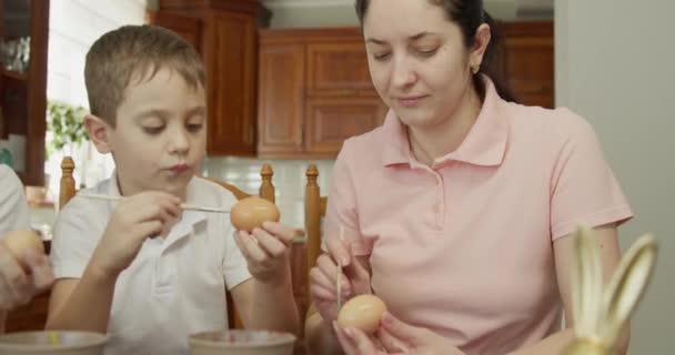 Mutter und Sohn bemalen ein Ei. Vorbereitungen für die Osterferien — Stockvideo