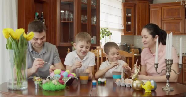 Καλό Πάσχα. Μια οικογένεια βάφει πασχαλινά αυγά. μητέρα, πατέρας και παιδιά βάφουν αυγά για τις διακοπές — Αρχείο Βίντεο