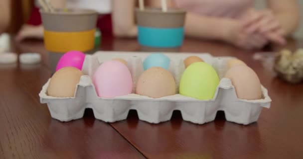 Algumas mãos tomam ovos de uma caçarola. Há alguns ovos pintados na caçarola para o feriado de Páscoa — Vídeo de Stock