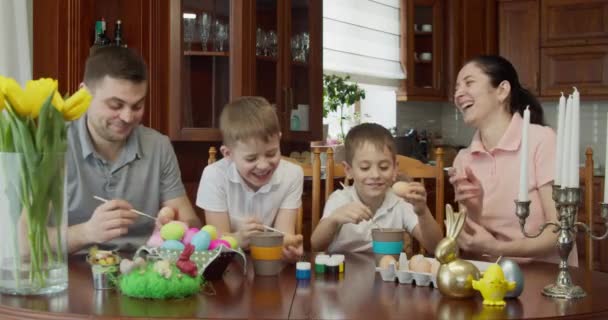 Пасхальная живопись - Семья с двумя мальчиками раскрашивают пасхальные яйца — стоковое видео