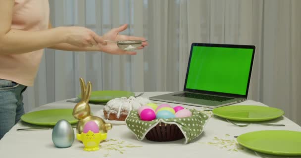 Wanita mengaplikasikan bubuk putih pada kue. layar komputer hijau. wanita mempersiapkan meja liburan — Stok Video