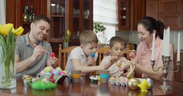 Pittura pasquale - Famiglia con due ragazzi che colorano le uova di Pasqua — Video Stock