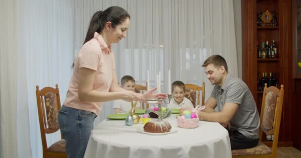 Mamma lägger pulvret på tårtan. fadern och de två pojkarna tittar — Stockvideo