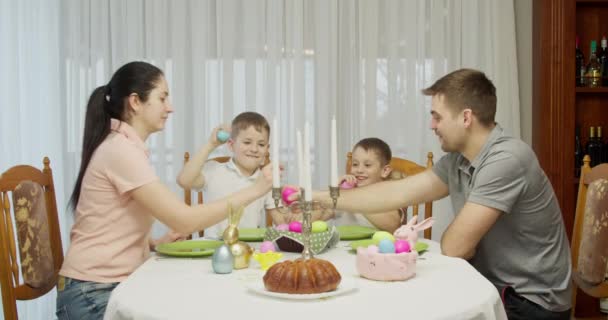 Frohe Ostern. Mama, Papa und Kinder haben Spaß beim Schlagen von Ferieneiern — Stockvideo