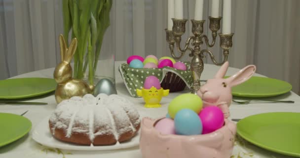 Stůl na velikonoční prázdniny. růžový králičí talíř s malovanými vejci, dort. Velikonoční atmosféra — Stock video