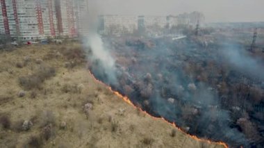 Orman ve arazi yangını. Kuru çimen yanıkları, doğal afet. Hava görüntüsü. Boş bir arazide güçlü ateş, yanan bir yerden güçlü duman. Alçak irtifada ateşin üzerinden uçuyor..
