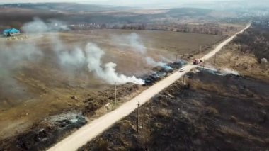 Orman ve arazi yangını. Kuru çimen yanıkları, doğal afet. Hava görüntüsü. Boş bir arazide güçlü ateş, yanan bir yerden güçlü duman. Alçak irtifada ateşin üzerinden uçuyor..