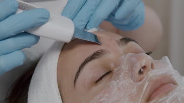 Esteticista usando equipamentos profissionais durante o tratamento de pele ultra-sônica procedimento de limpeza facial no salão. Conceito de clínica de beleza — Vídeo de Stock