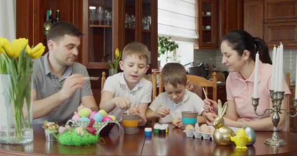 Ambiente pascal. família pintar ovos de Páscoa. os meninos ficar sujo com tinta enquanto joga — Vídeo de Stock