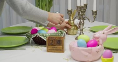 Yarın kadın Paskalya yemeği için tatil masasını hazırlıyor.