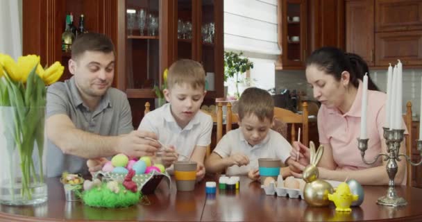 Gelukkig familie schilderij Paaseieren in de keuken — Stockvideo