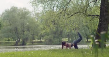 Parkta sabah yoga egzersizi yapan zinde bir kadın. Huzur ve konsantrasyon. Sağlıklı yaşam tarzı