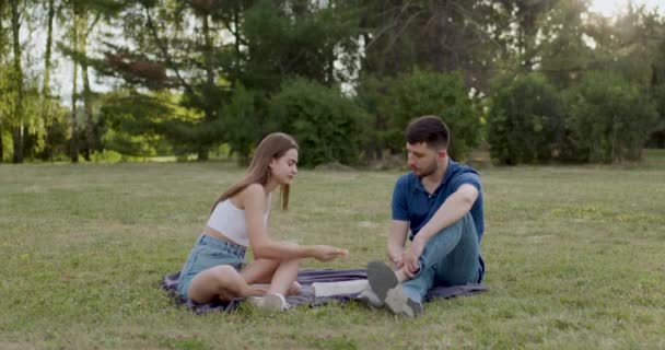 ピクニックでは白い服を着た女性が彼氏に食べさせるか箸で青で服を着て — ストック動画