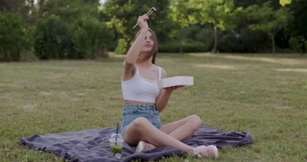 Młoda Dama Ubrana Biały Shirt Niebieskie Fartuchy Siedząca Trawie Podnosi — Wideo stockowe