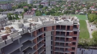 Güneşli günlerde zemini olan evin inşaatı, sağdan sola üst manzara. Beton bloklar ve kırmızı tuğla