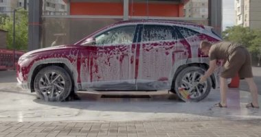 man washing her car in a self service car wash station.Car wash self-service.