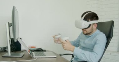 brunette man wearing 3d glasses, happy that he won the game. Happy man in a virtual games office. Concept of modern technologies