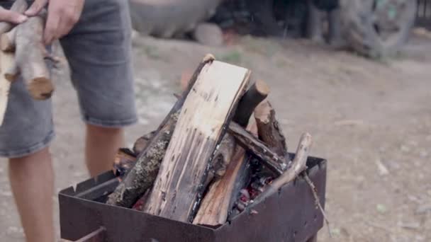 Man Prepares Light Fire Long Cut Wood Wood Placed Brazier — Stockvideo