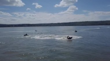 Suda motosikletle yarışan birkaç genç arasındaki spor müsabakaları. Dron üst görünümü, dairesel üst görünüm