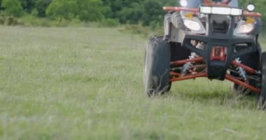 Ormanda hızla giden bir ATV 'nin yakın çekimi. Kötü yollarda kolayca giden bir ATV 'nin tekerlekleri. Ekstrem sporlar ve ormanda tatil kavramı.