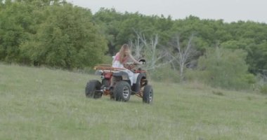 4 tekerlekli ATV kullanan bir kadın. Arazi aracı hareket halinde. ATV 'de test sürüşü. Ekstrem spor anlayışı, sağlıklı yaşam tarzı.