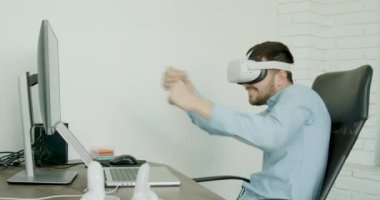 Sanal oyunlarda oynayan genç bir öğrenci. Modern bir ofiste mavi gömlekli neşeli esmer adam. en modern yenilikler
