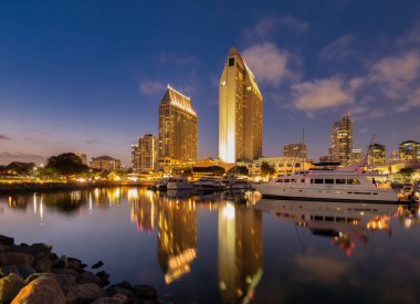 San Diego 'daki altın renkli Manchester Grand Hyatt Oteli alacakaranlıkta sakin marinayı yansıtıyor