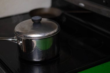 Siyah sobanın üstünde buharlı tencere.. 