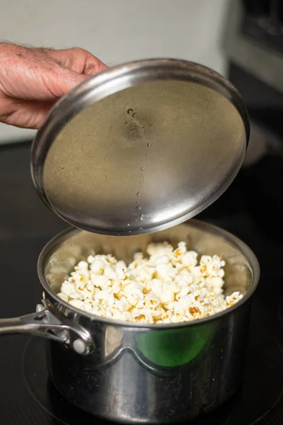 Lève le couvercle du pot révélant pop-corn chaud — Photo