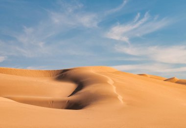 Arizona, Yuma yakınlarındaki imparatorluk kum tepeleri. Mavi gökyüzü ve kabarık beyaz bulutlu bir hava.