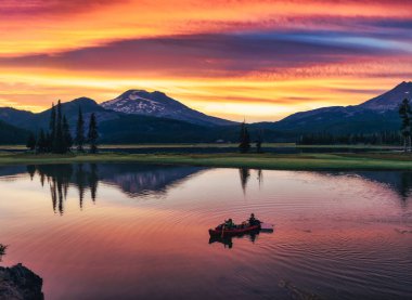 Scenic sunrise at Sparks Lake with people in canoe.  clipart